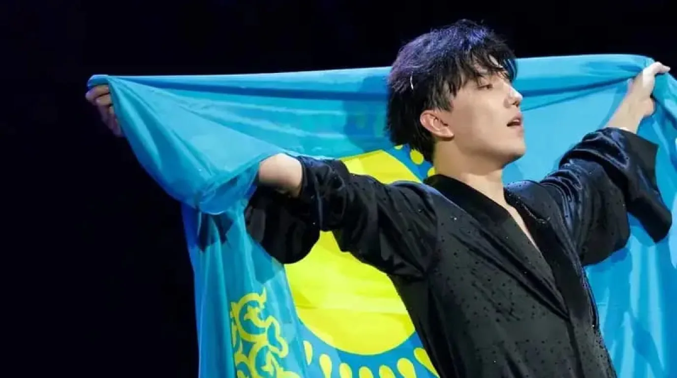 Dimash Kudaibergen performing on stage with dramatic lighting during a concert