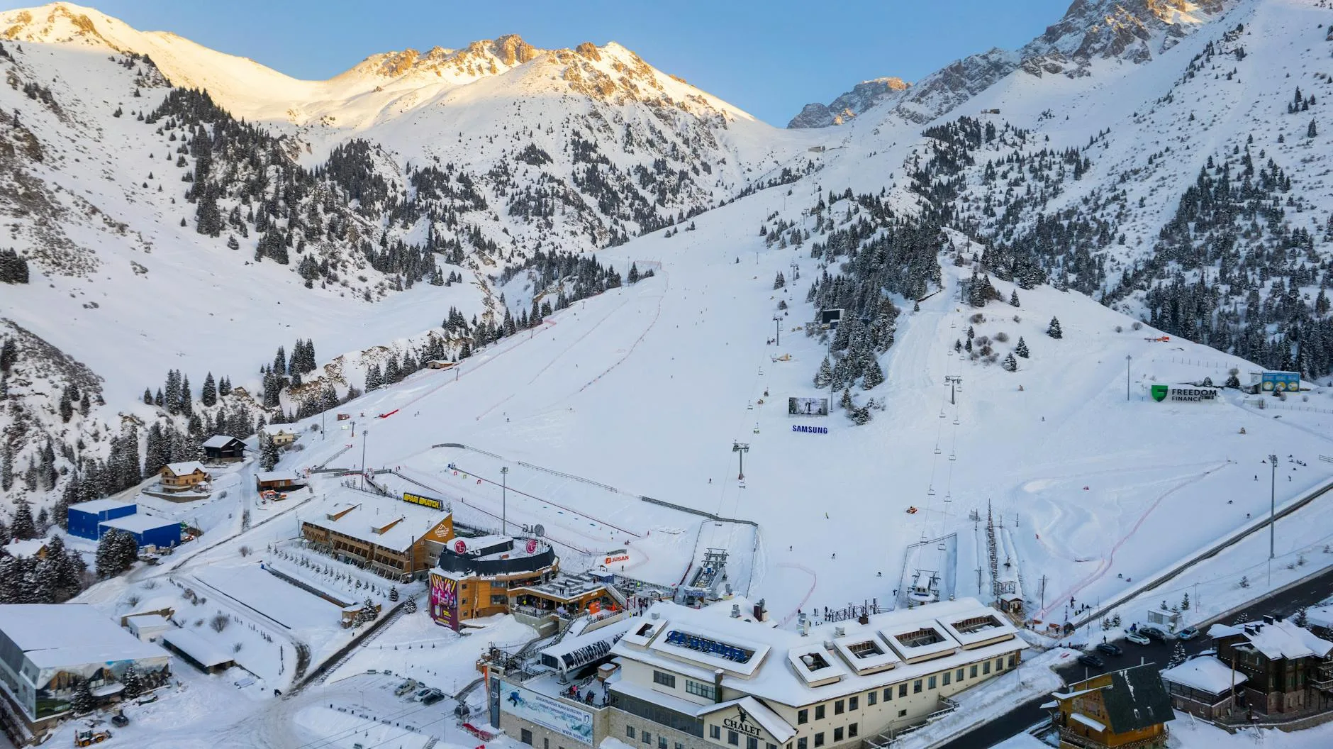 Shymbulak ski resort slopes with snow-capped Zailiysky Alatau mountains in the background